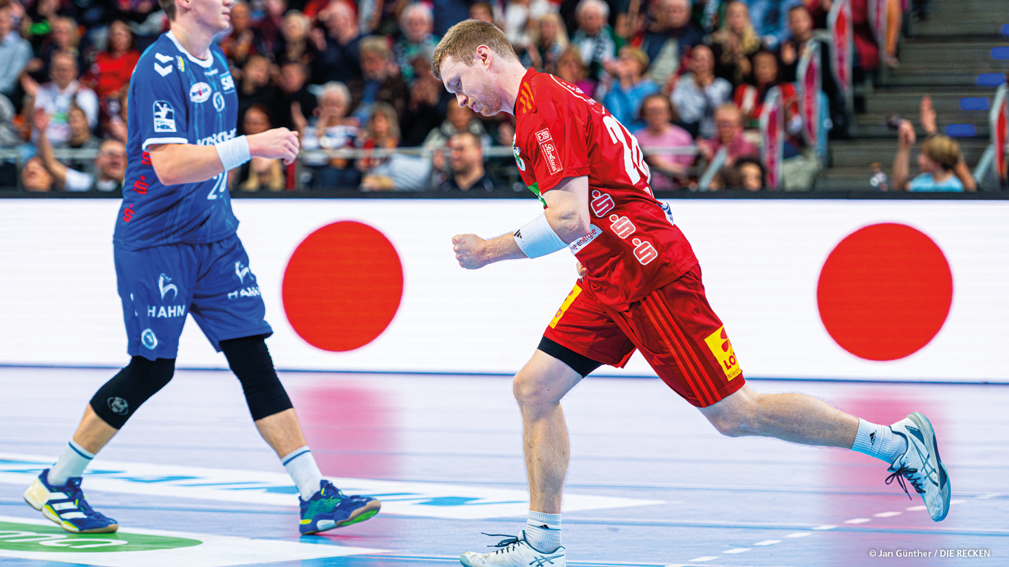 Handballer im roten Trikot mit Parlasca Logo auf dem Ärmel läuft über blauen Hallenboden