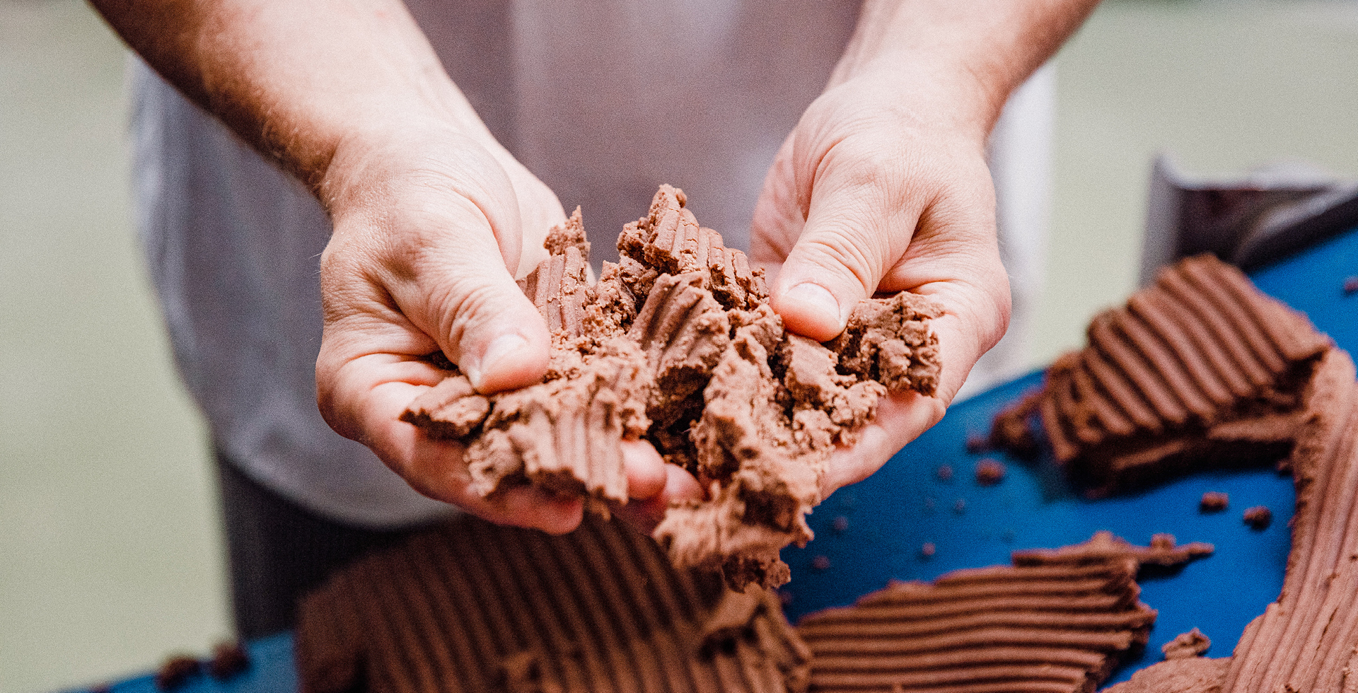 Zwei Hände halten frischen Kakao-Keksteig