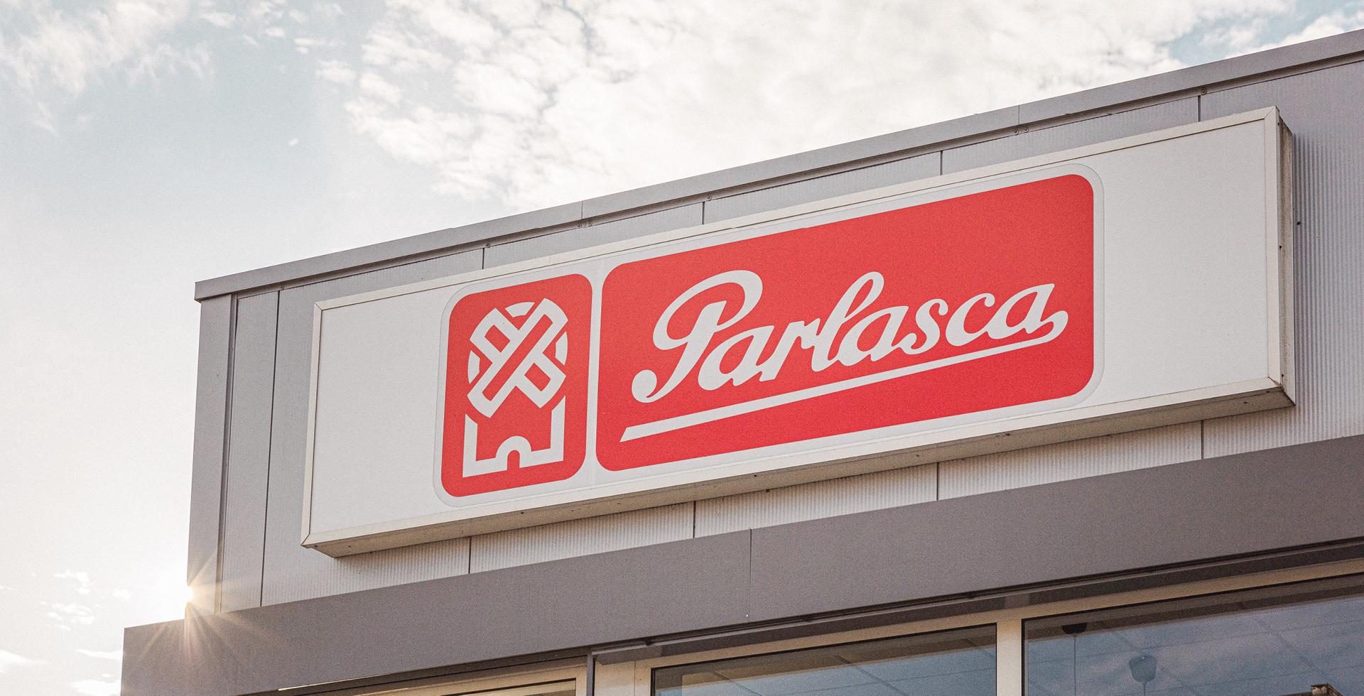 Firmenschild von Parlasca an einem Gebäude bei Tageslicht mit blauem Himmel im Hintergrund